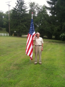 Dad in the front yard saluting.